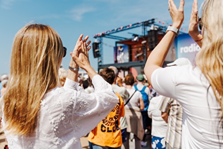 Mensen klappen voor podium op zeedijk