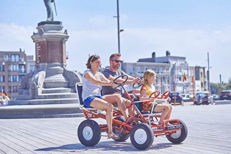 Drie personen op een typische go-cart of 'billenkar'